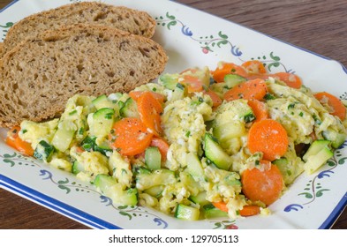 Scrambled eggs with vegetables and bread