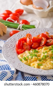 Scrambled eggs with white bread and herbs, fresh orange juice