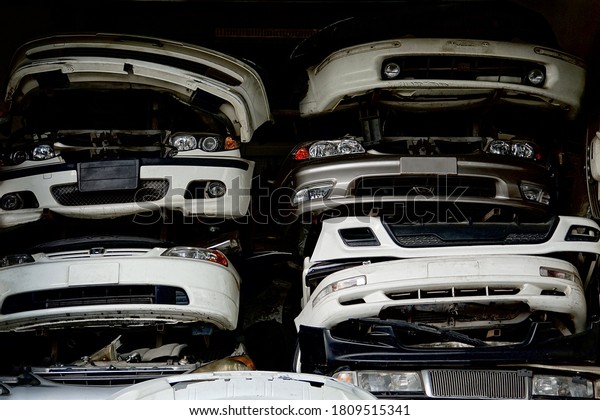 Scrap\
of car head. Strange picture of a car business in Asia. Scrap car\
headlights, bumpers, headlights in a scrap shop, spare parts of\
used cars. Shop front in  Black market car\
parts.