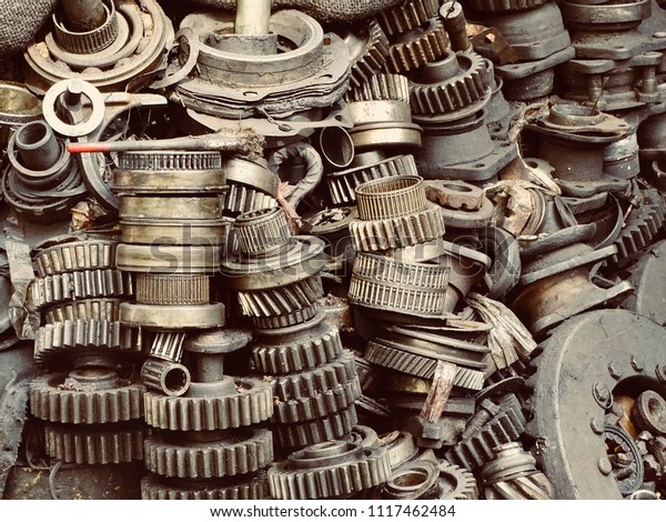 Scrap Car and machinery Parts. Scrap parts in\
garage wall. Scrap parts removed from used cars and machinery.\
Parts isolated from the unused car and machinery. Scraps for second\
used part shop. Gears.