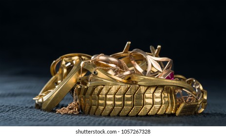 A Scrap Of Gold. Old And Broken Jewellery, Watches Of Gold And Gold-plated On A Dark Background.