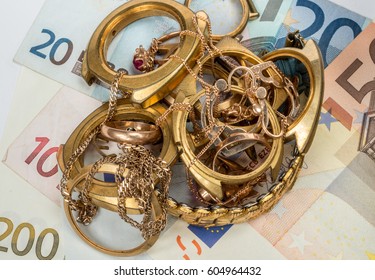 Scrap Of Gold. Old And Broken Jewelry, Watches On A Background Of Euro Banknotes.
