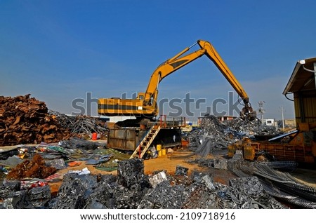 Scrap pile tidying with excavator