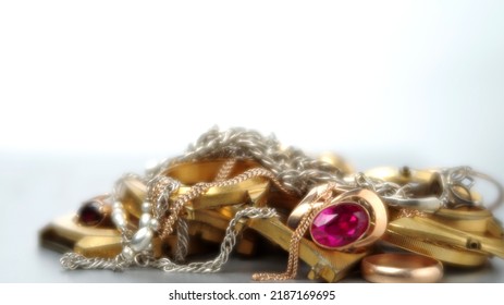 A Scrap Of Precious Metals In Soft Focus. Old And Broken Gold And Silver Jewelry, Watches Of Gold And Gold-plated Lies In A Pile. Selective Focus.