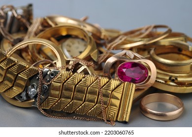 A Scrap Of Precious Metals In Soft Focus. Old And Broken Jewelry, Watches Of Gold And Gold-plated Lies In A Pile. Selective Focus.