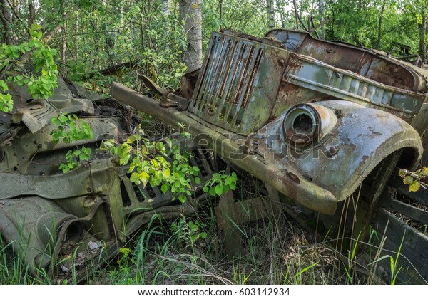 Scrap yard in the Chernobyl Exclusion Zone with\
old military vehicles and other scrap that was disposed after the\
nuclear disaster