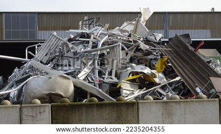 Scrap yard with old iron and sheet metal from cars, appliances, shelves, tin rails and corrugated metal roofing