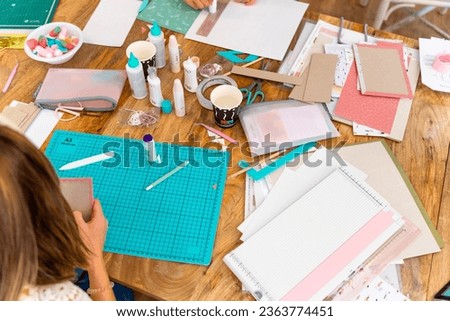 Scrapbook workshop. Work table. Tools, cardboard and papers for the workshop