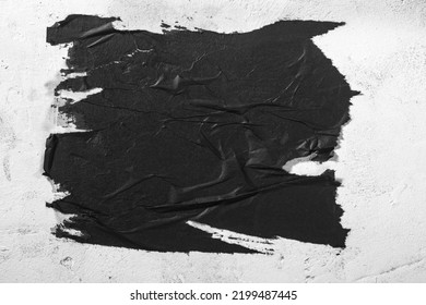 Scraps of black paper on a white wall.