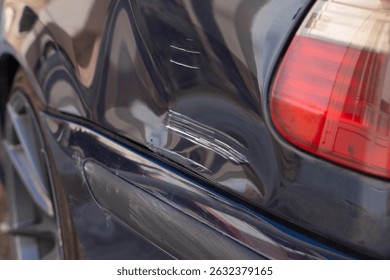 Scratch and dent on car panel, vehicle damage, often resulting from minor collisions or accidents. Damaged car paint need for timely repairs