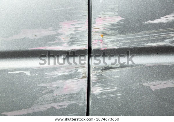 scratched car accident consequences, close-up of\
damage to car doors insured\
event.