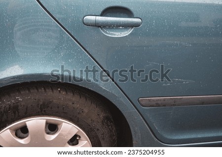 Scratched car on the back door - detail of damaged blue car