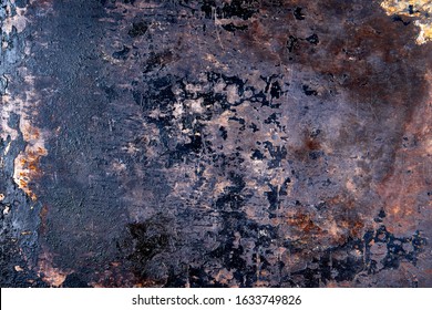 Scratched, chipped, rusty metal surface with peeling black enamel. Old kitchen baking tray pan with traces of many years of use.