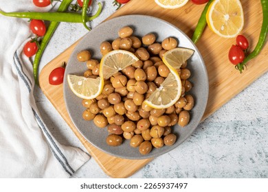 Scratched green olives. Brined scratched green olives on a wood serving board. Top view - Powered by Shutterstock