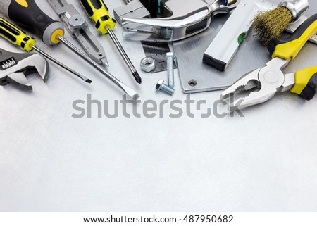 scratched metal background with yellow tool set and instruments for hand work and fixing