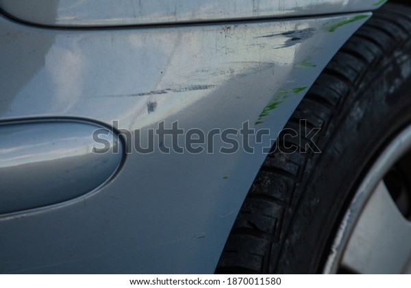Scratches and\
bumps on the body of a light blue\
car