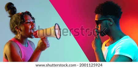 Scream and silence. Young african girl screaming on loudspeaker opposite silent guy isolated over multicolored backgrounds. Concept of emotions, facial expression