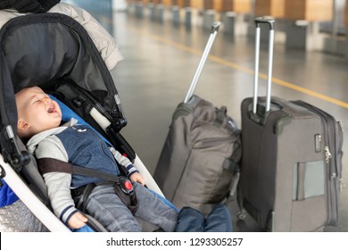 Screaming Baby Boy Sitting In Stroller Near Luggage At Airport Terminal. Child In Carriage Near Check-in Desk Counter. Children Tears, Panic And Hysterics. Travelling With Small Children Concept.