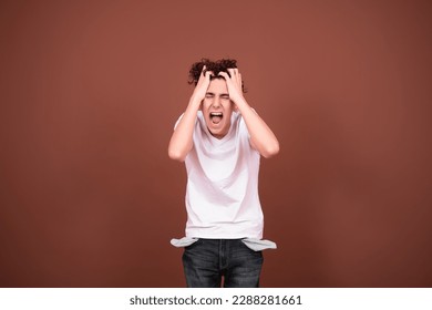 Screaming bankrupt man with empty pockets. Debts and lending. Brown background. - Shutterstock ID 2288281661