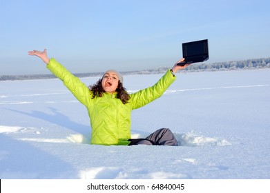 screaming girl with laptop siting among snow.