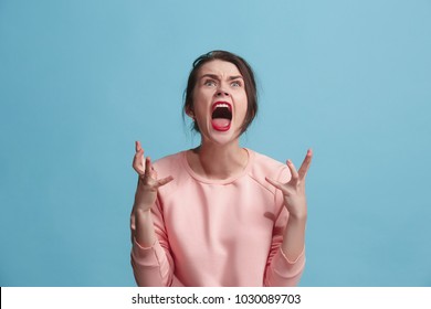 Screaming, hate, rage. Crying emotional angry woman screaming on blue studio background. Emotional, young face. Female half-length portrait. Human emotions, facial expression concept. Trendy colors - Shutterstock ID 1030089703