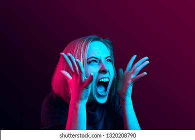 Screaming, Hate, Rage. Crying Emotional Angry Woman Screaming On Neon Studio Background. Emotional, Young Face. Female Half-length Portrait. Human Emotions, Facial Expression Concept. Trendy Colors