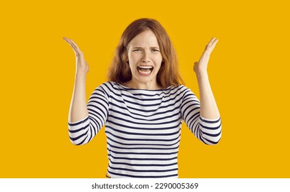 Screaming, hate, rage. Portrait of crying emotional young woman who is screaming feeling angry and furious. Crazy frustrated caucasian girl screaming and shouting isolated on orange background.