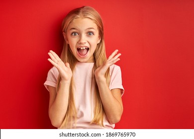 Screaming Kid Girl Is Surprised, Glad To See Someone Or To Get Something. Looks At Camera With Opened Mouth