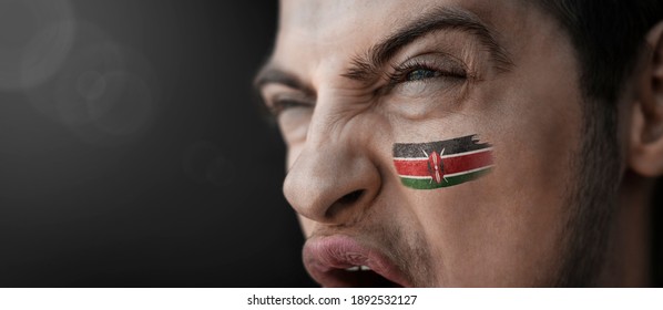 A Screaming Man With The Image Of The Kenya National Flag On His Face.