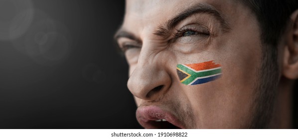 A Screaming Man With The Image Of The South Africa National Flag On His Face.