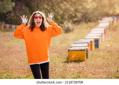 Screaming Woman Was Attacked By An Aggressive And Dangerous Swarm Of Killer Bees In A Honey Apiary. The Concept Of Allergy And First Aid After Being Stung By Insect Venom.