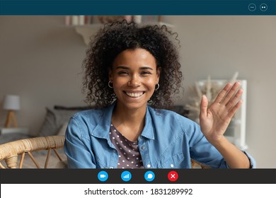 Screen application view of smiling millennial African American woman wave greet talking on video call at home. Happy young biracial female have pleasant webcam digital virtual online conference.