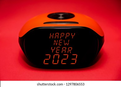 screen of electronic alarm clock - happy new year - words on black screen. idea of happy 2023 new year and merry christmas. red letters.                     
