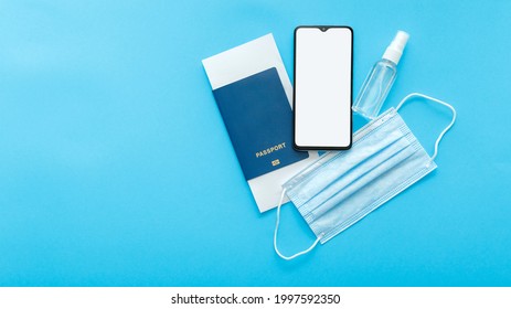 Screen Mockup Smartphone Blank For Green Pass Covid Test App, Passport Plane Tickets Medical Mask Sanitizer. Travel Vaccination On Blue Background With Phone Mock Up. Long Web Banner With Copy Space