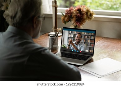 Screen view of mixed race young man talking to mature father. Old man 60s uses laptop for video call, chatting online with adopted son. Senior male student watching webinar, teacher speaking at webcam - Powered by Shutterstock