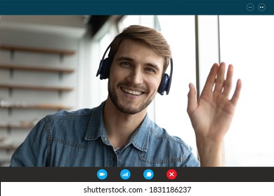 Screen view portrait of smiling young Caucasian man in headphones wave greet talk speak on video call at home. Happy male in earphones have webcam virtual digital conference on computer online. - Powered by Shutterstock