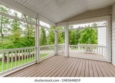 Screened-In Wooden Porch With White Railings Overlooking Green Backyard Area