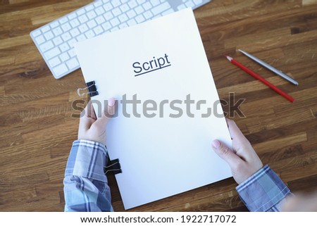 Screenwriter holds folder of documents labeled script. Development of plots for films and series concept