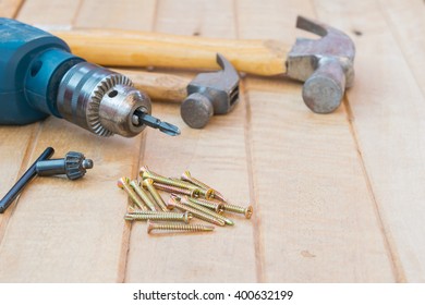 Screw And Electric Drill On Wood