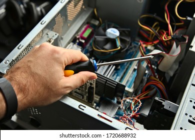 A screwdriver being held by a computer technician. 