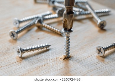 Screwdriver drill a screw into wood plank ,DIY maker and woodworking concept. selective focus - Powered by Shutterstock