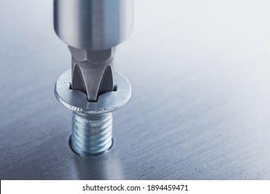 Screwdriver screw in metal steel plate bolt. Spanner, bolt, screw and nuts.