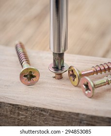 Screwdriver And Screw On Wood