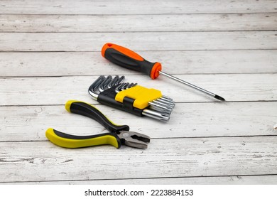 Screwdriver, Torx Wrench, Pliers On A Wooden Table