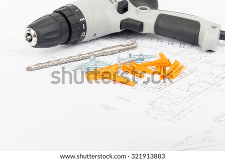 Screwer on draft with drill and screws, close up view