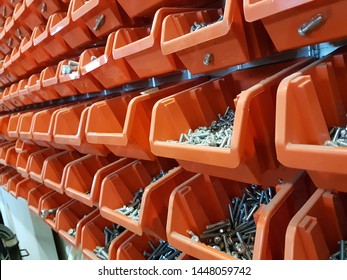 Screws in orange storage boxes in a workshop
