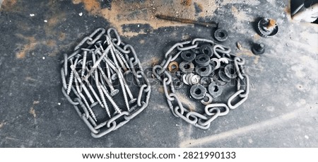 Screws, rings, and chains on the rusty metal plate.