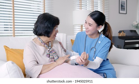 Scrub Nurse Doctor Using Digital Tonometer Check Blood Pressure For Old Asia Female At Home In Elderly Care Cardiovascular Medical Visit, Cholesterol Problem And Hospice Healthcare Caregiver Concept.