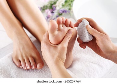 Scrub, scrub with pumice dead epidermis.Foot care treatment and nail, the woman at the beautician for pedicure.