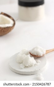 Scrub In Wood Spoon With Jar And Coconut On White Background. Home Spa Treatment Concept, Organic Cosmetic. Vertical Photo. Copyspace